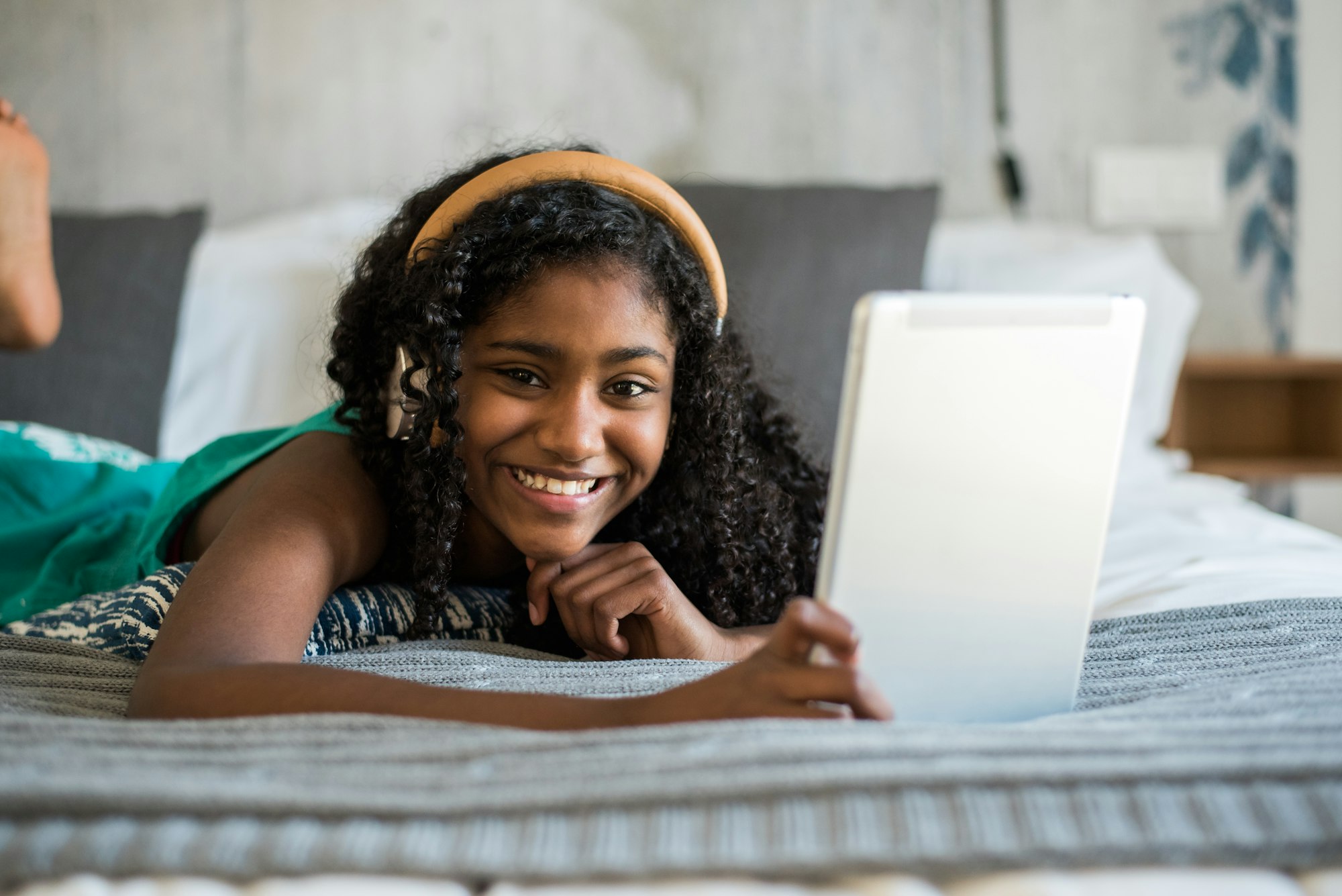 Black teenage reading a book on bed