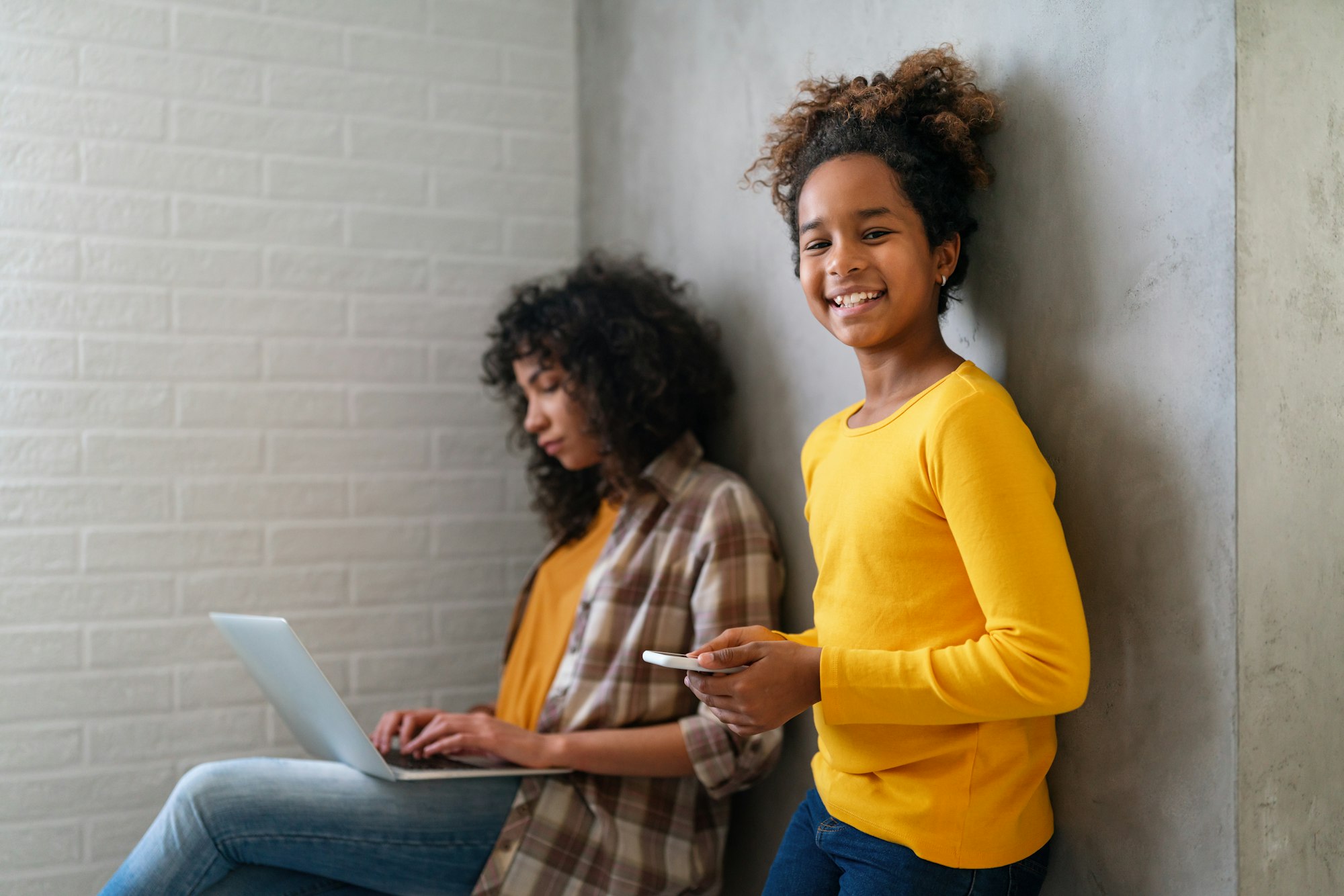 Happy black teenager girls using digital gadget to having fun or studying together.