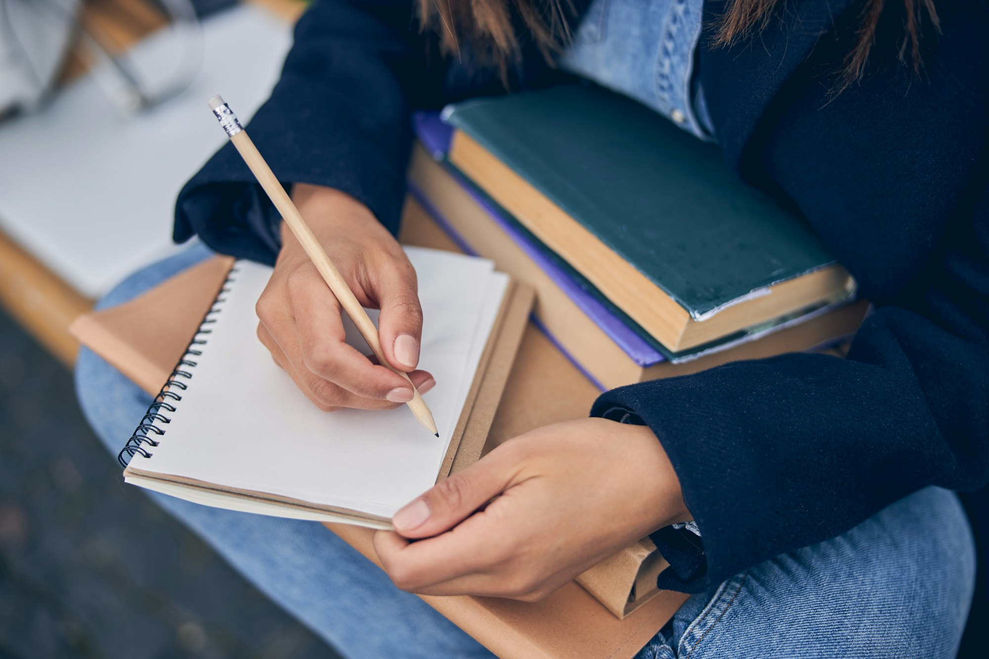 Lady in spring clothes holding books on her knees