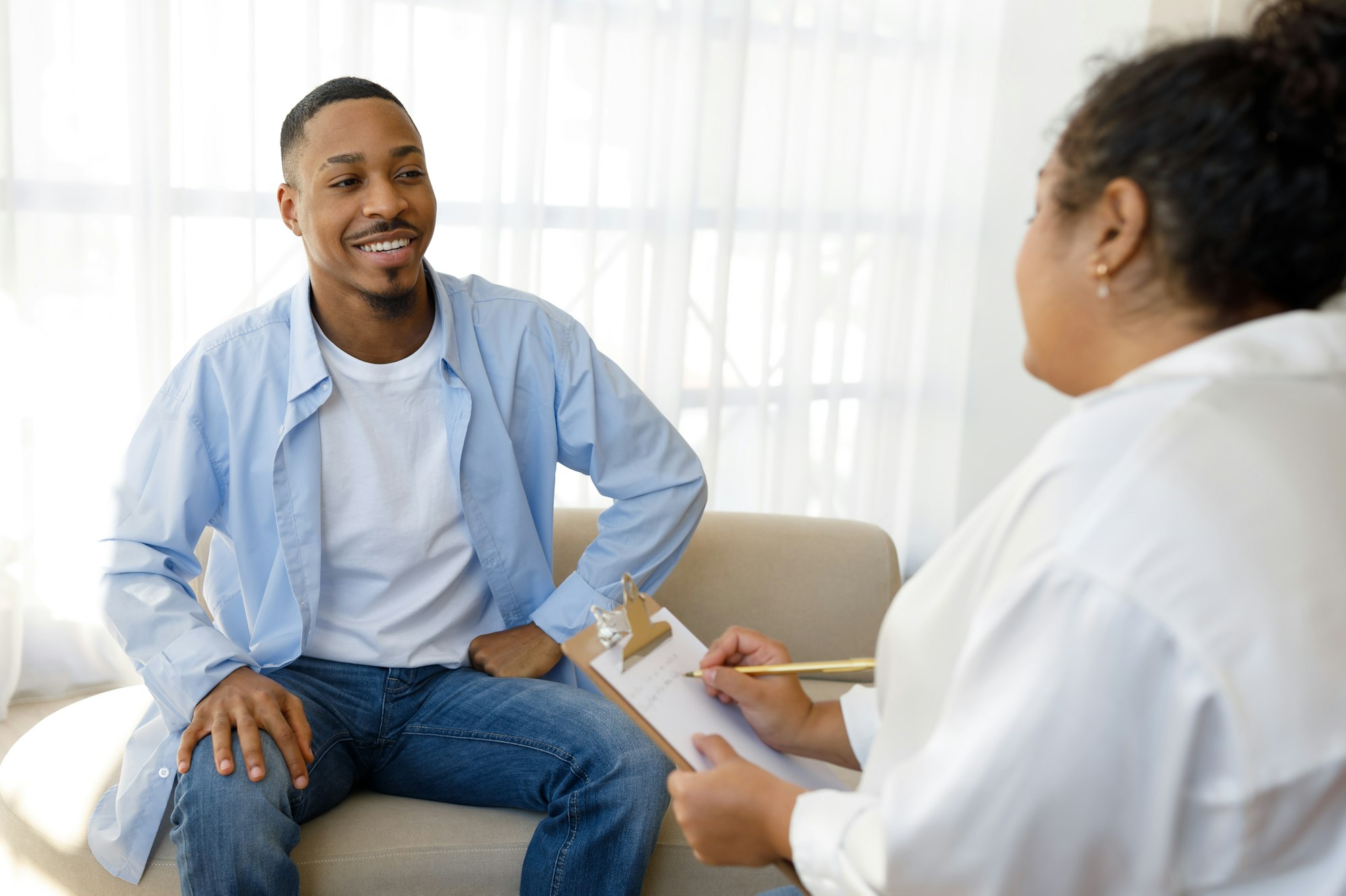 Positive black guy sharing good results of therapy with psychologist