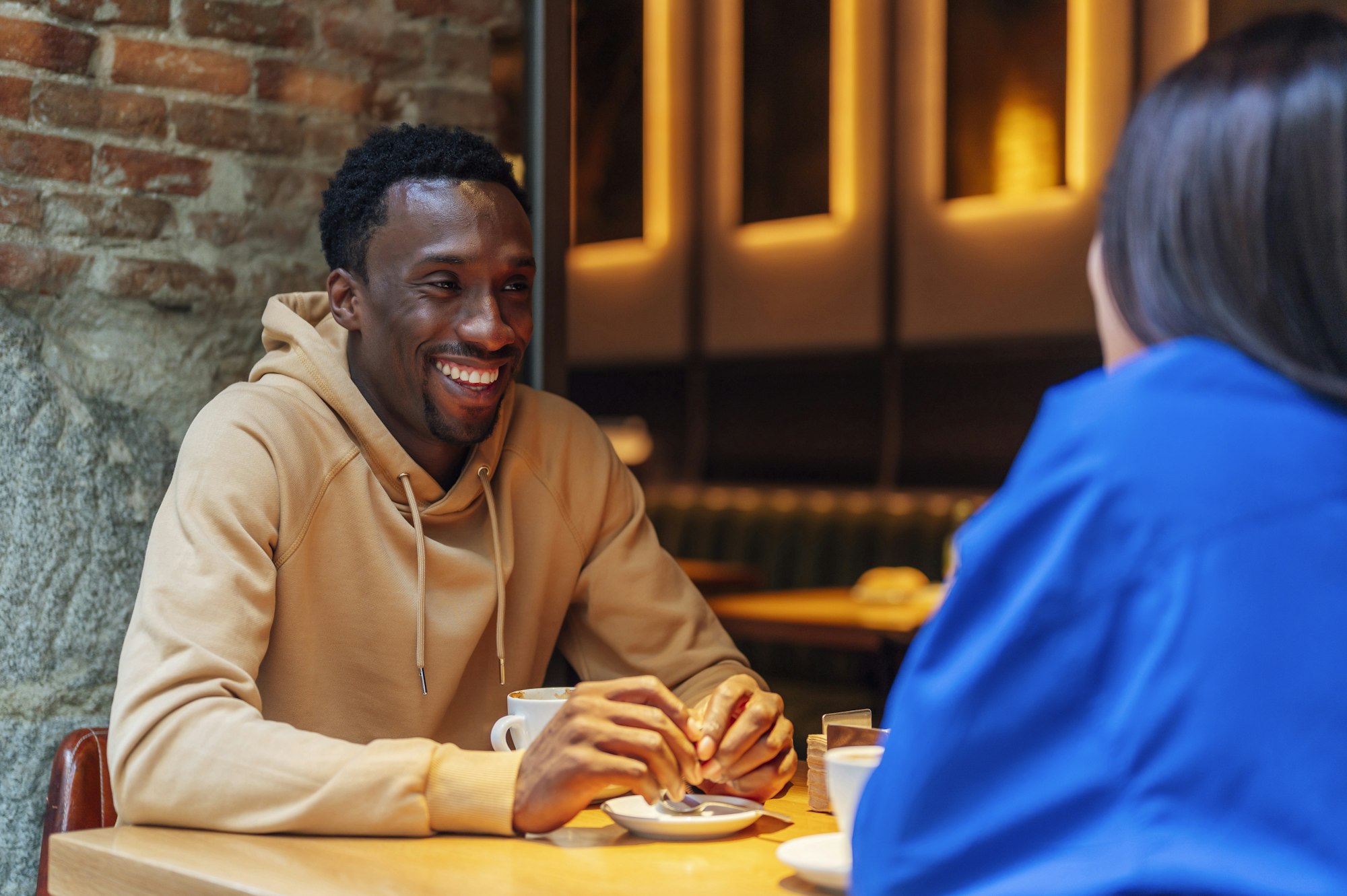 smiling african american young guy drinking coffee with a friend