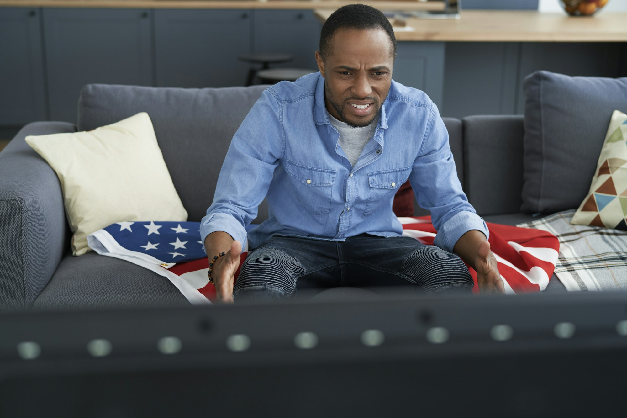 High angle view of frustrated man watching TV